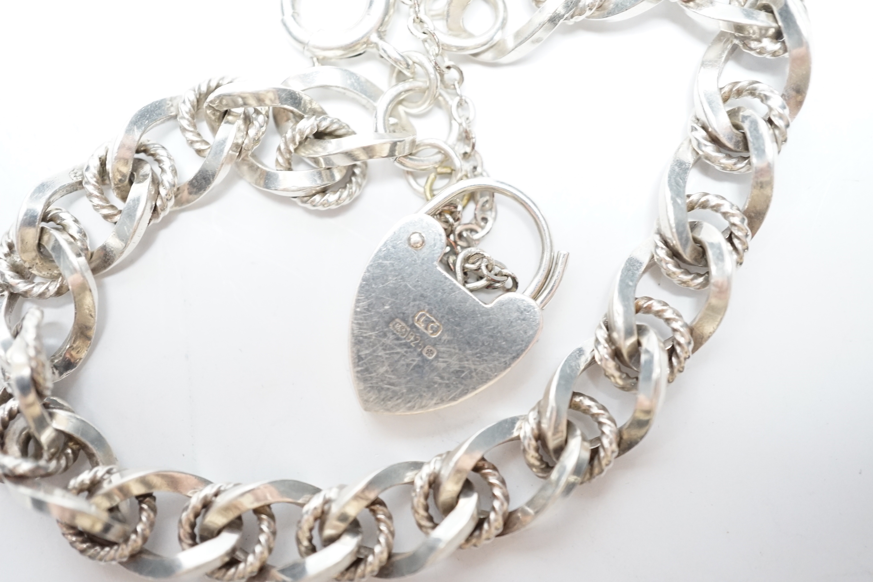 A modern silver curb and rope twist link bracelet, with heart shaped padlock clasp, 18cm.